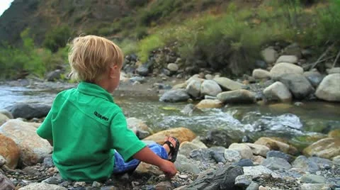 Toddler throwing rocks into stream-slowmo MVI 9356 Stock Footage 9025950