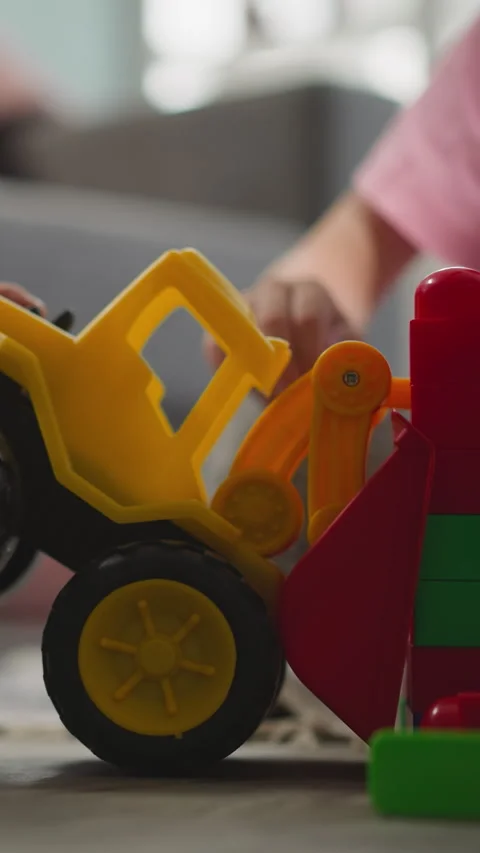 Toddler tries to move wall built with small blocks by sister Stock Footage 287740237