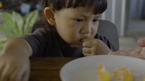Toddler Is Trying To Spit Out Orange Seed 01 Stock Footage 329212142