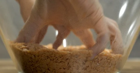 Toddler using bare hand to play with lentil seeds Stock Footage 99952178