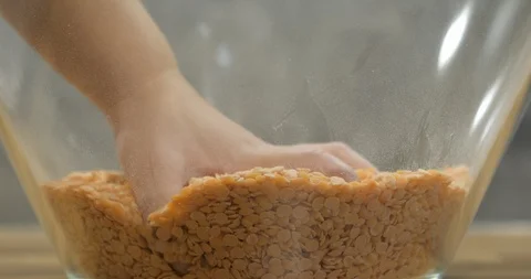 Toddler using bare hand to play with lentil seeds Stock Footage 99952242