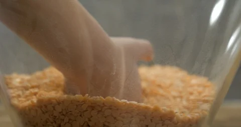 Toddler using bare hand to play with lentil seeds Stock Footage 99952510