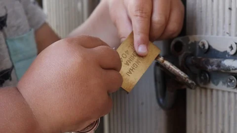 Toddler using keys and playing with a lock and latch Stock Footage 100524507