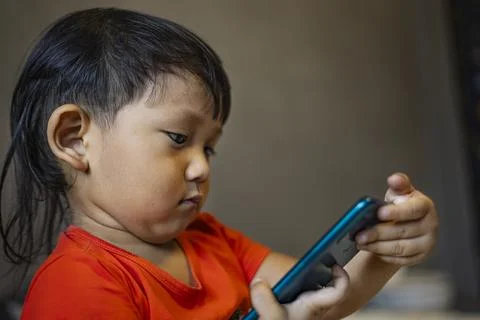 Toddler Using Smartphone To Call His Mother In The Room Stock Photos