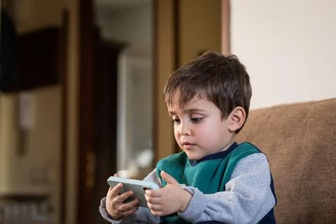 Toddler Using a Smartphone, Engaged in Digital Entertainment Stock Photos