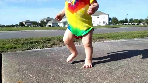 Toddler walking barefoot down sidewalk Video stock 71163663