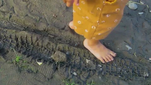 Toddler walking on damp ground Stock Footage 197375447