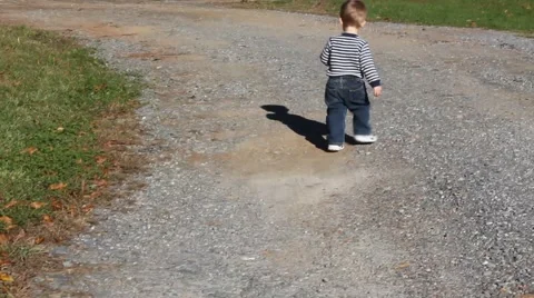 Toddler walking down a road Stock Footage 44447823