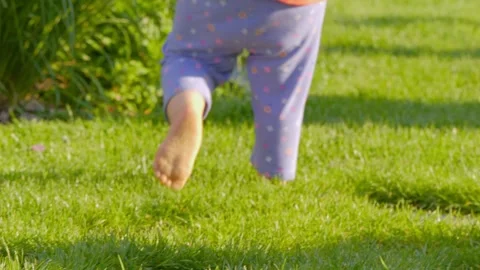 Toddler walking on a garden path, steps of growth in 4k slow motion 120fps Stock Footage 284520474