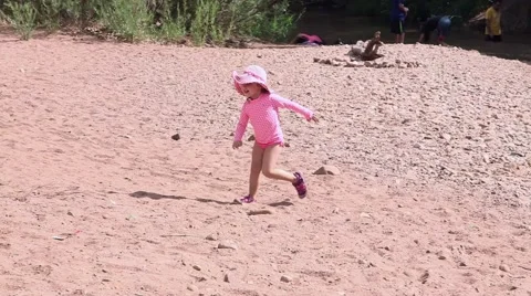 Toddler walking on riverbed Stock Footage 43386579