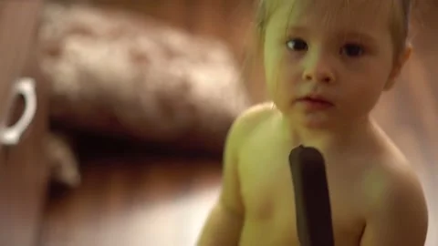 Toddler without clothes eats ice cream in chocolate and watches tv Stock Footage 153132452