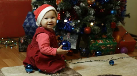 Toddlers next to a Christmas tree returns to camera Stock Footage 57668913