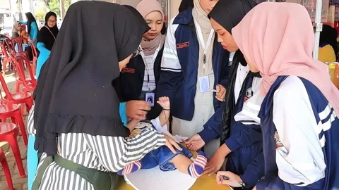 Toddlers take part in the immunization program at Posyandu Video stock 293227754