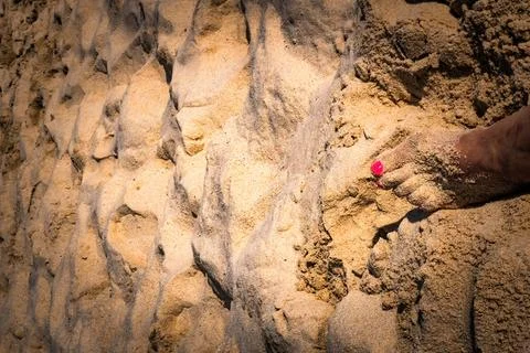 Toenails painted in the sand on the beach. Unrecognizable. Copy space. Stock Photos