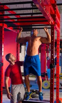 Toes to bar man pull-ups personal trainer Stock Photos