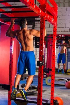 Toes to bar man pull-ups 2 bars workout Stock Photos