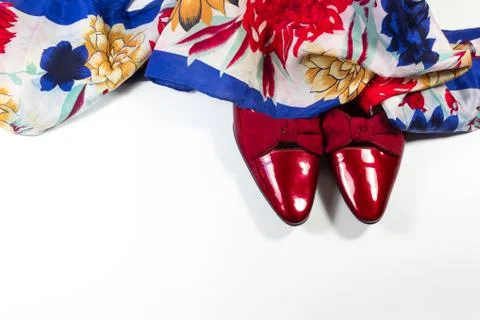 Toes of women's ruby red patent leather shoes with bows, draped with a scarf Foto stock