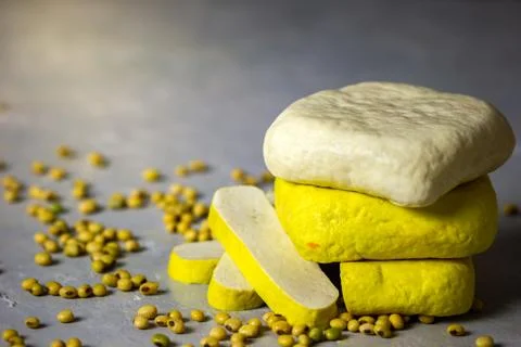 Tofu stacking on table and soybean seeds scattered on the table. Stock Photos