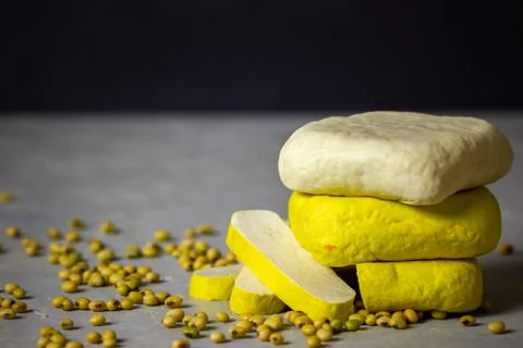 Tofu stacking on table and soybean seeds scattered on the table. Stock Photos