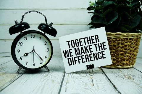 Together We Make The Difference text on paper card with alarm clock on wood.. Stock Photos