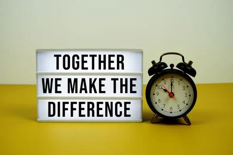 Together We Make The Difference text on light box with alarm clock on yello.. Stock Photos