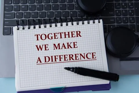 TOGETHER WE MAKE A DIFFERENCE - words on a white sheet on the background of.. Stock Photos