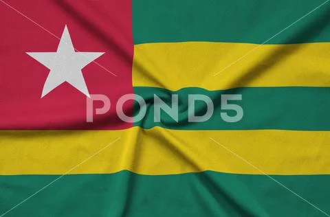 Togo flag is depicted on a sports cloth fabric with many folds. Sport team b Stock Photos
