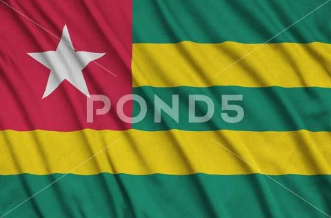 Togo flag is depicted on a sports cloth fabric with many folds. Sport team b Stock Photos