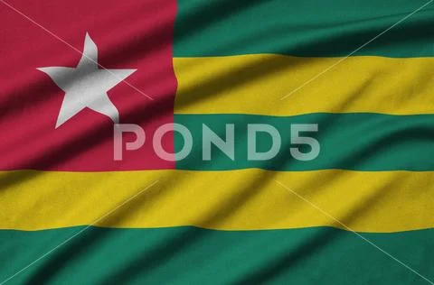 Togo flag is depicted on a sports cloth fabric with many folds. Sport team b Stock Photos