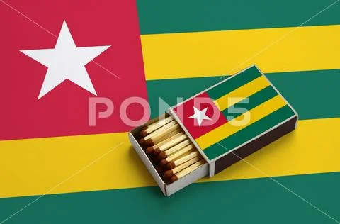 Togo flag is shown in an open matchbox, which is filled with matches and lie Stock Photos