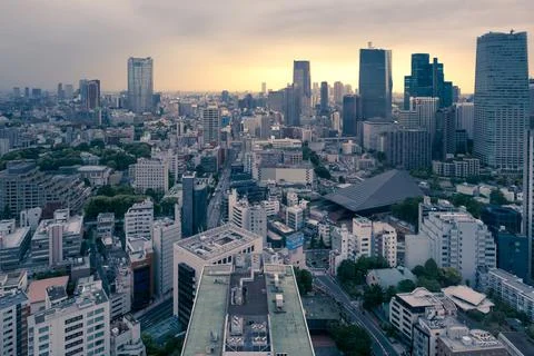Tokyo, Japan - 12.05.2019: Dramatic yellow sunset under heavy grey clouds in the Stock Photos