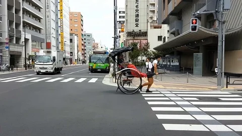 Tokyo, Japan passengers on a moving rickshaw carriage. Stock Footage