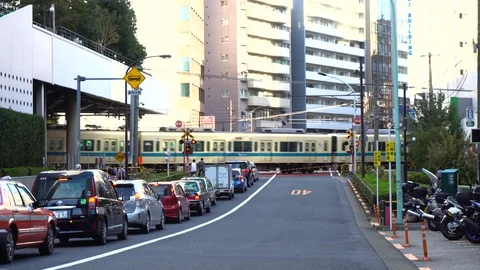 Tokyo, Japan - Train Crossing At Level crossing While Cars Wait Behind Barrier Stock Footage 97699567