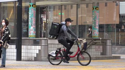 TOKYO, JAPAN : Uber Eats food delivery at the street. Stock Footage 129493111
