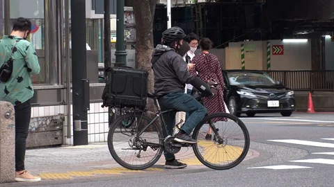 TOKYO, JAPAN : Uber Eats food delivery at the street. Stock Footage 129493349