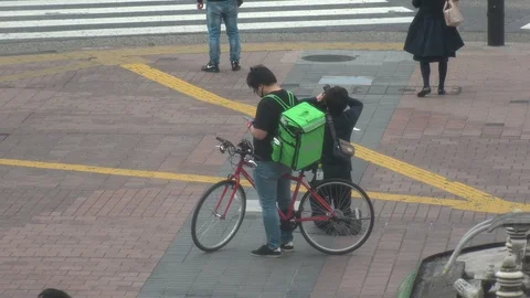 TOKYO, JAPAN : Uber Eats food delivery at the street. Stock Footage 129493425