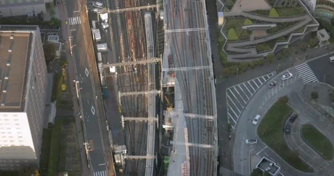 Tokyo rail traffic from above with train city roads and modern buildings below Stock Footage 323798060