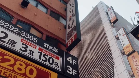 Tokyo skyline pan view. Sunlight over colorful advertising billboards in Stock Footage 130658494
