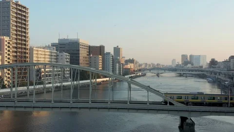 Tokyo train crossing Sumida River Bridge, Aerial Rise Japan Establishing Shot Stock Footage