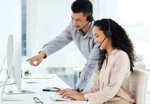 Told you it would work if you clicked here. two call centre agents working Stock Photos