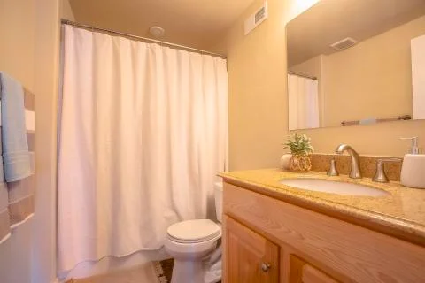 Toliet and vanity area inside a bathroom with towel rod and mirror on the wall Stock Photos