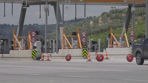 Toll booth with caution signs, red lights, and orange cones in landscape, Stock Footage 327310691