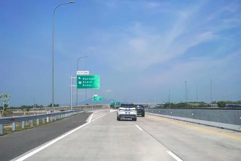 Toll road at the exit intersection with direction signs to Nganjuk, Kediri an Stock Photos