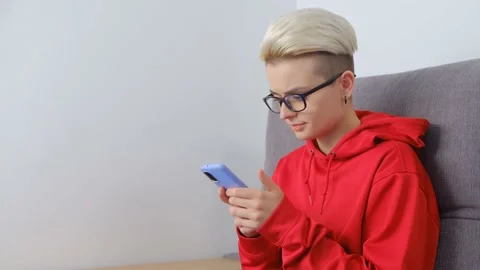 Tom boy girl using mobile phone for communication and entertainment online Stock Footage 172190694