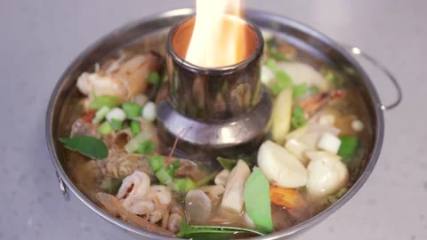 Tom yum soup simmering in pot, spicy prawn Thai sour soup, fresh herbs shrimp Stock Footage