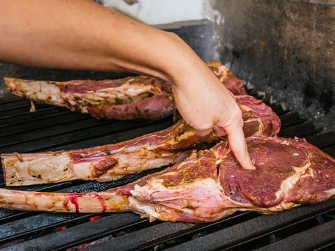 Tomahawk rib beef steak on hot black grill with flames Stock Photos
