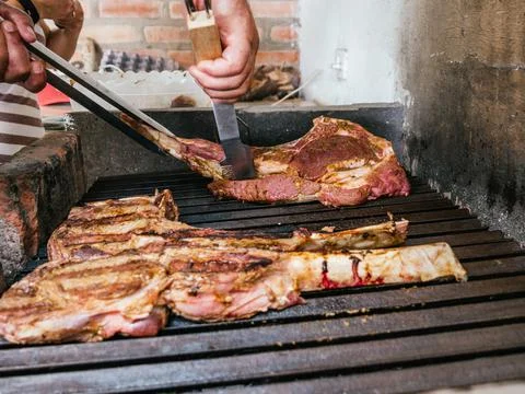 Tomahawk rib beef steak on hot black grill with flames Stock Photos