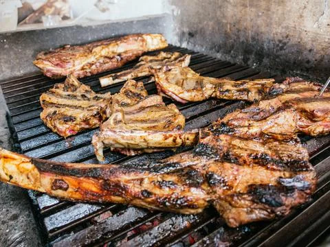 Tomahawk rib beef steak on hot black grill with flames Stock Photos