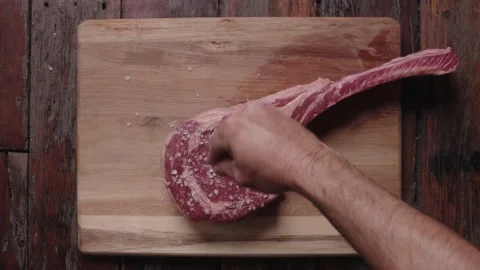 Tomahawk steak being salted Stock Footage 194717659