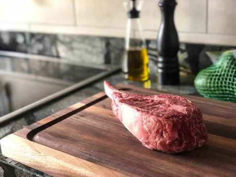Tomahawk steak on kitchen prep counter Stock Photos